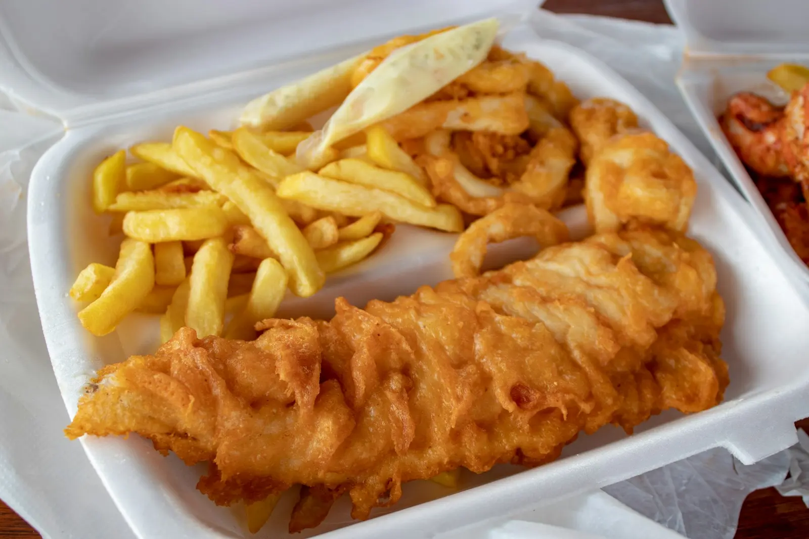 Battered fish and chips in a paper tray