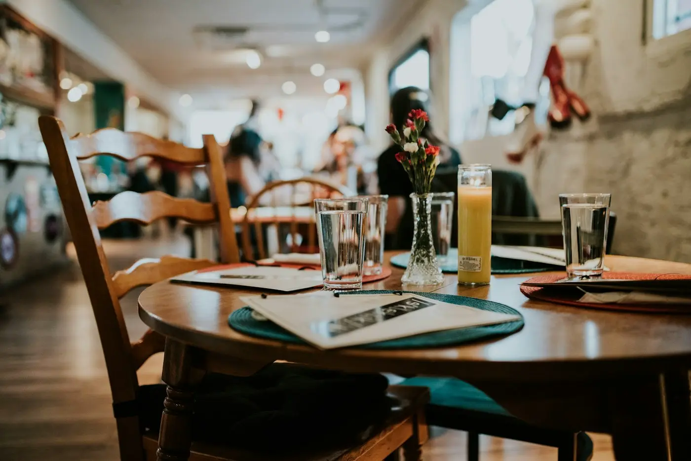 A restaurant table set with plates, cutlery and water glasses